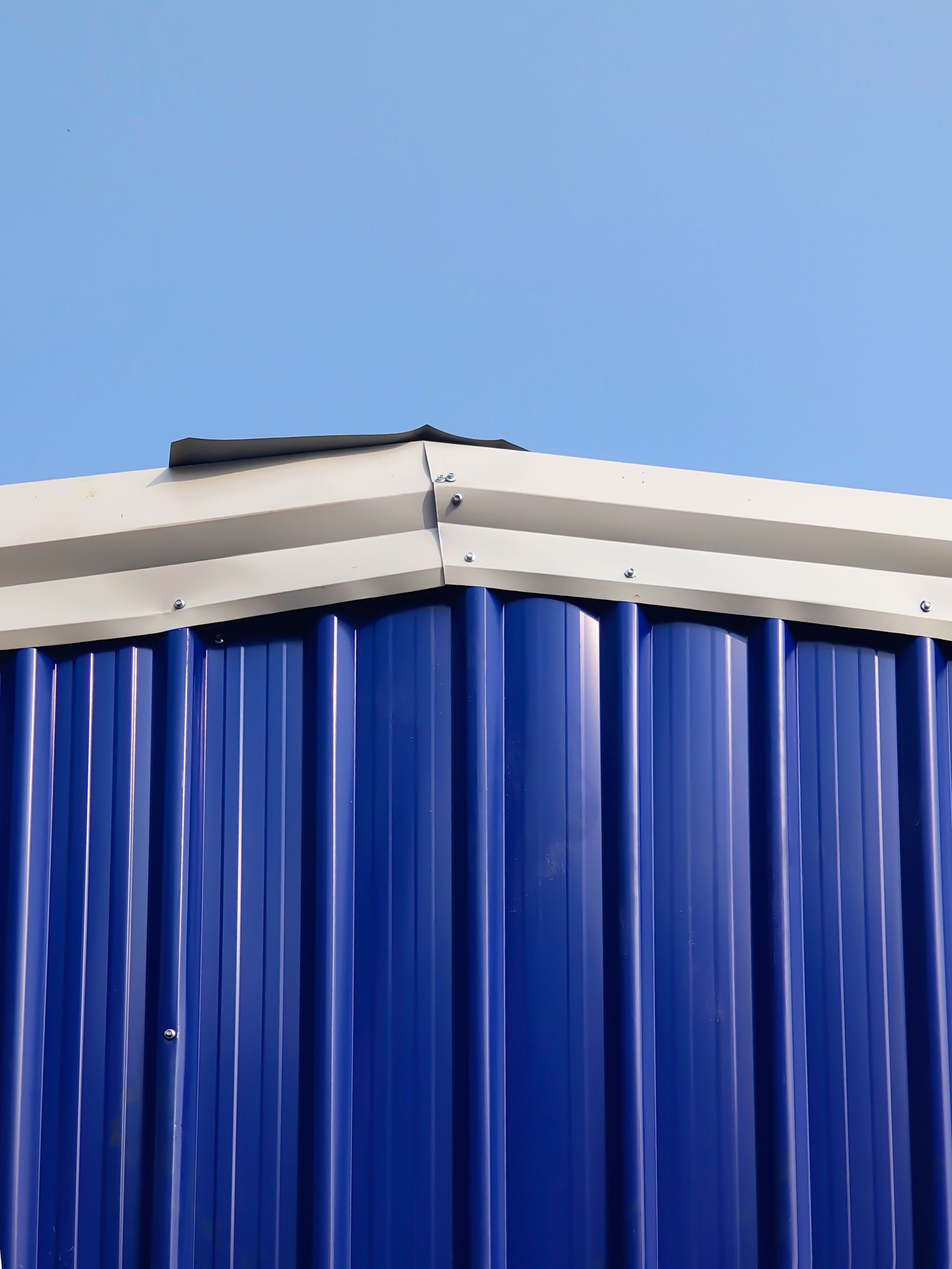 Graphite standing-seam metal roof panels meeting a clean eave line