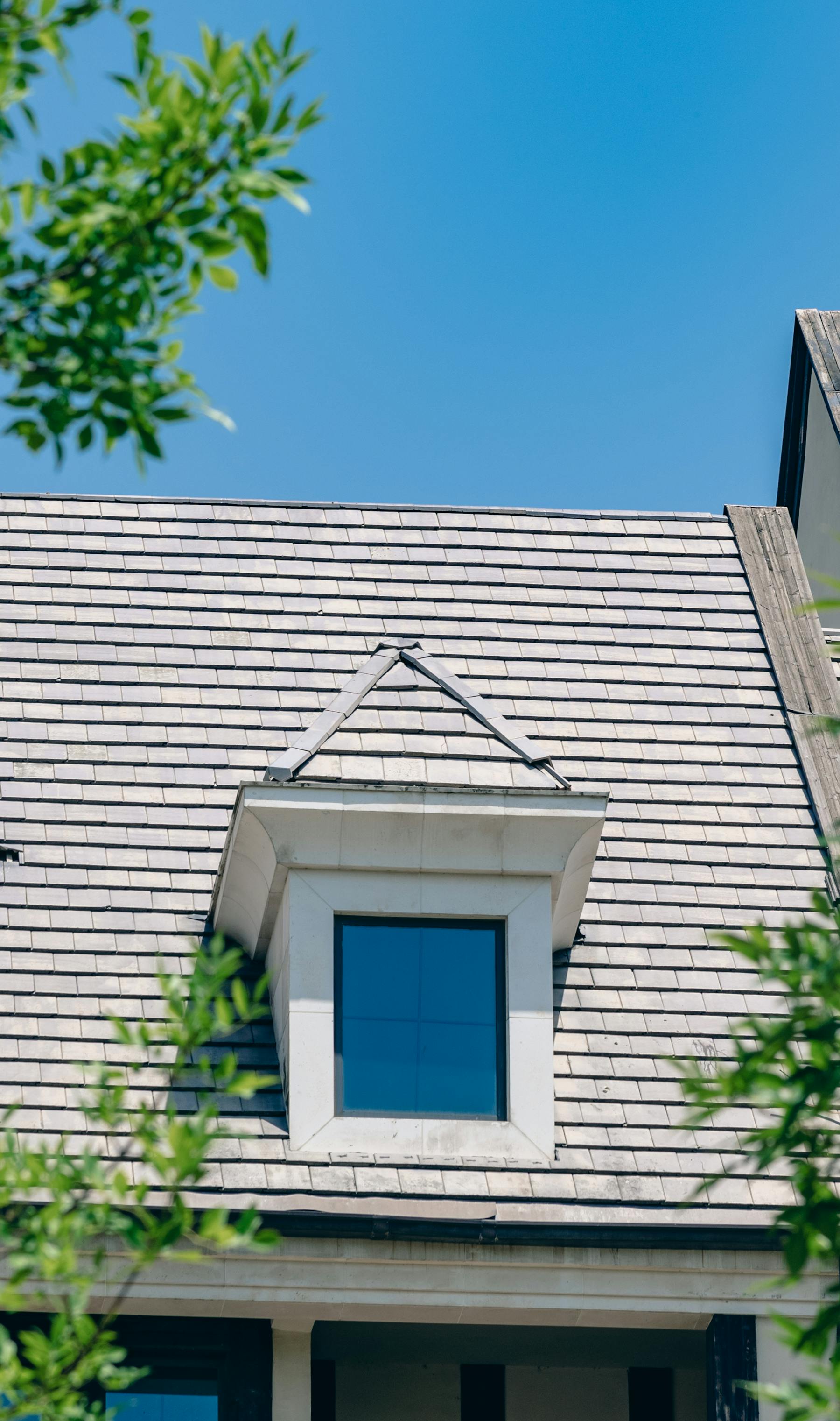 Classic dormer window on a steep dark-shingle roof of a brick Toronto semi