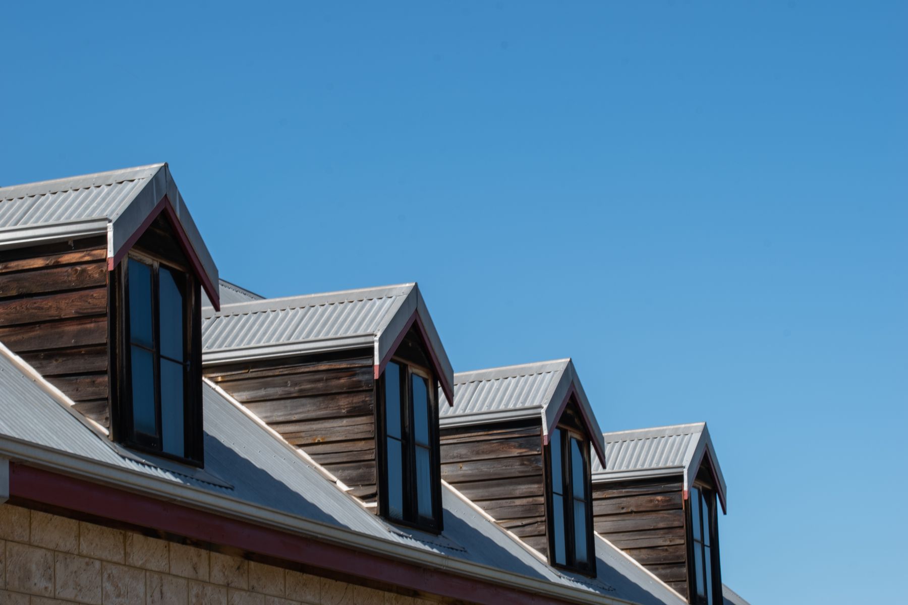 Elevated view of dark shingle rooftops with dormers in a leafy Toronto neighbourhood